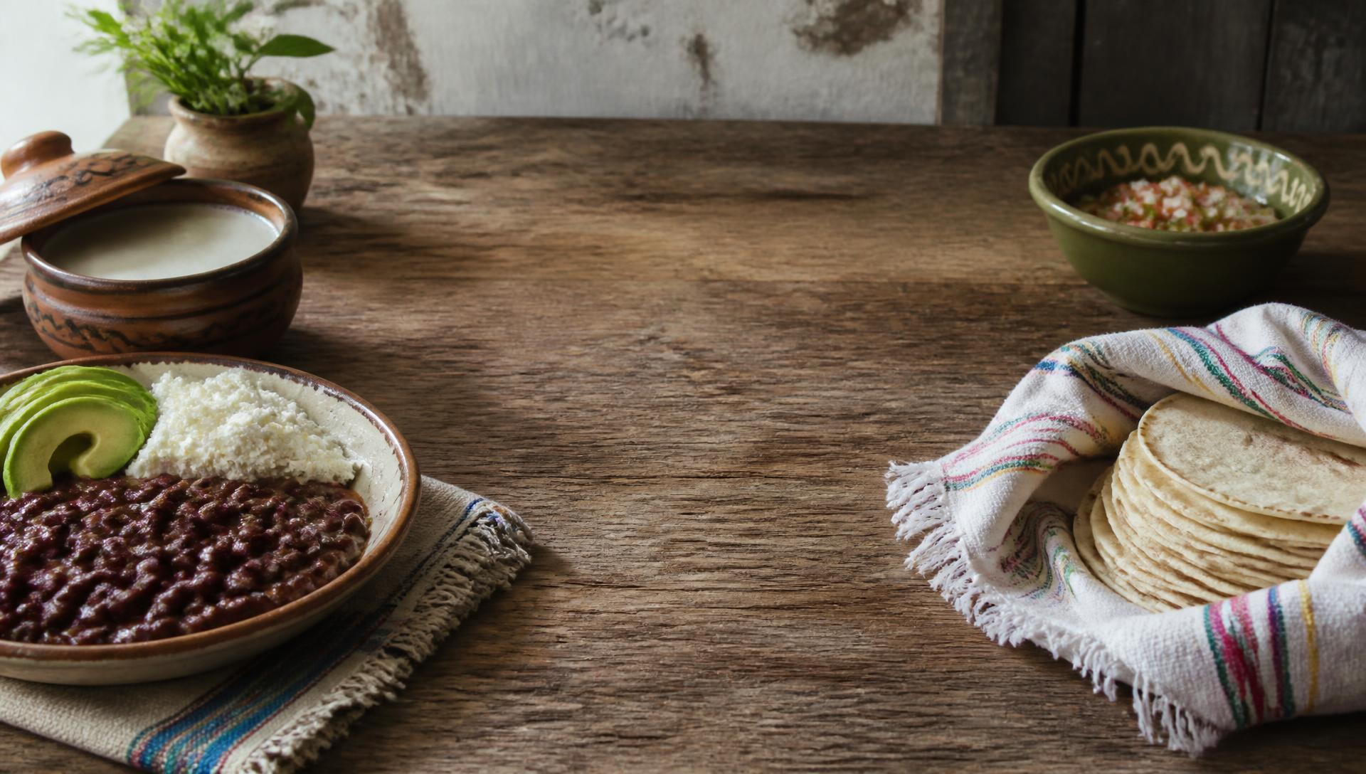 Mesa hondureña con frijoles, quesillo, aguacate y tortillas de maíz envueltas en un textil
